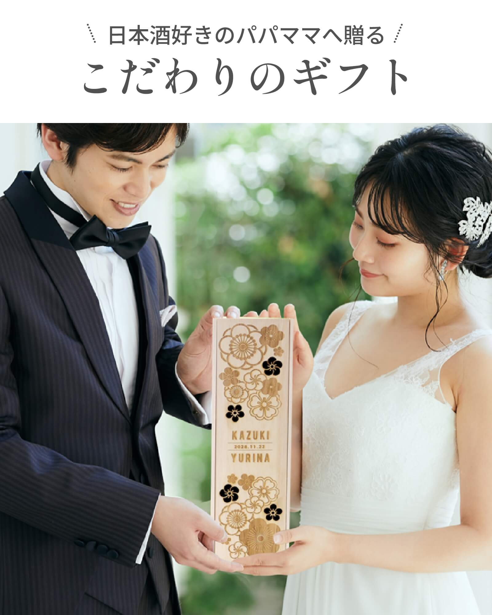 梅や桜などめでたい柄の木箱に日本酒が入ったギフトを持っている新郎新婦
