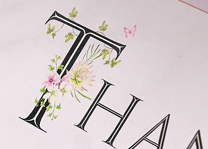 英文字には可憐なお花が咲き、幸運を運ぶとされる蝶も舞っています