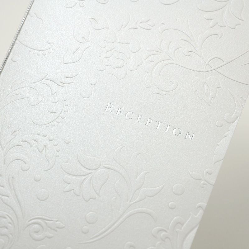 シルバーの箔押しボタニカル柄のエンボスが美しい席次表表紙