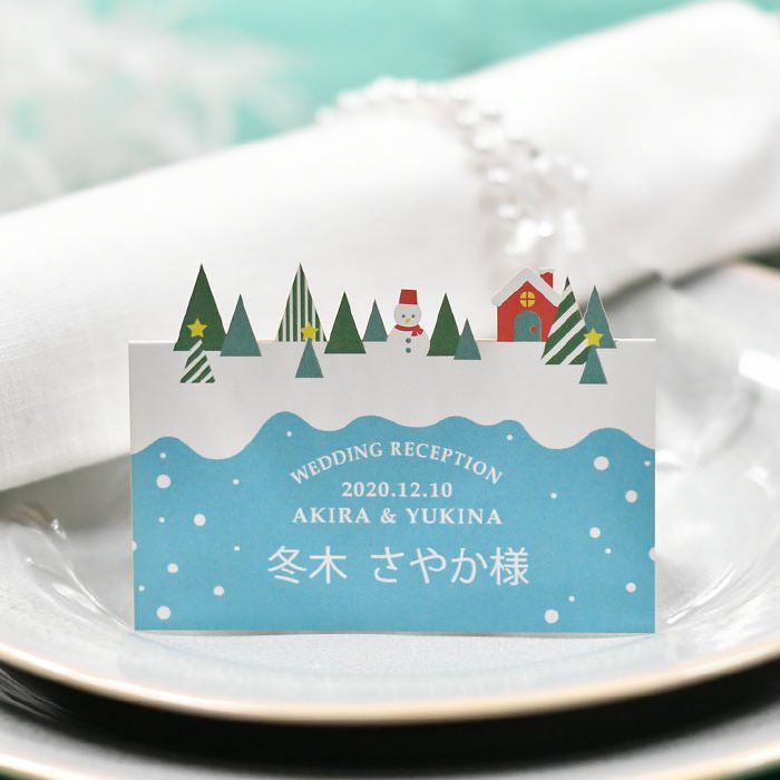 雪の降る森にツリーやスノーマンが型抜きされていて、まるで仕掛け絵本の1ページのような心ときめくデザイン