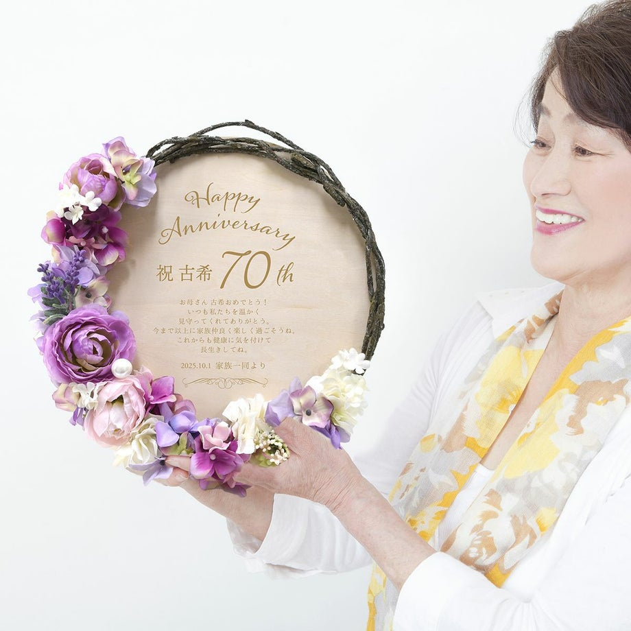 木製ボードにレーザー刻印する古希祝いギフトを持っているシニア女性