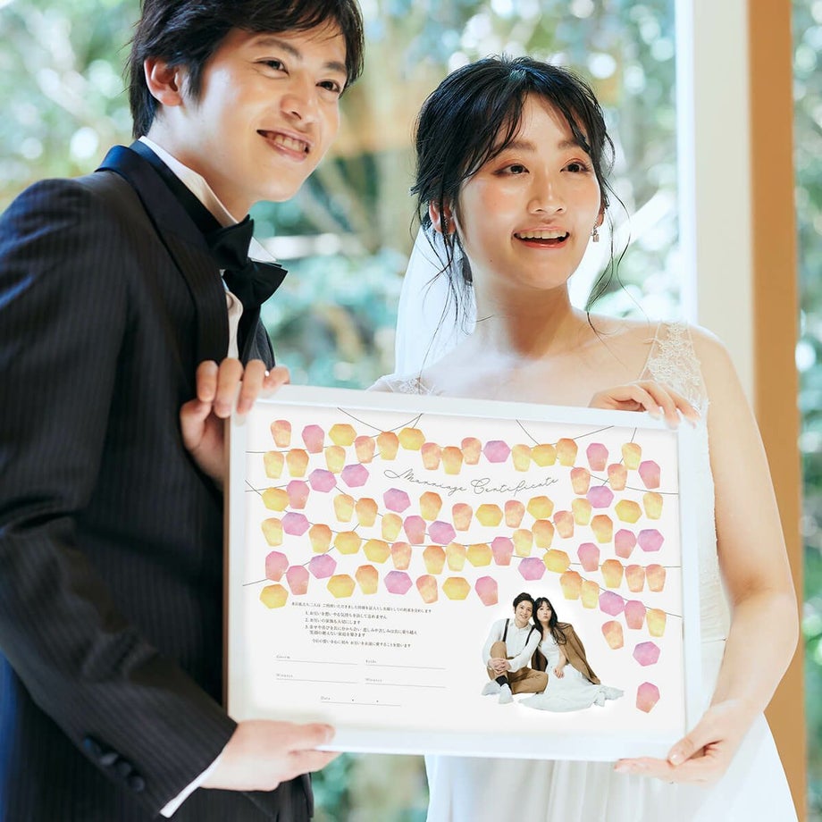 おしゃれな無数のランタンをイメージしたデザインの結婚証明書をかかげる新郎新婦