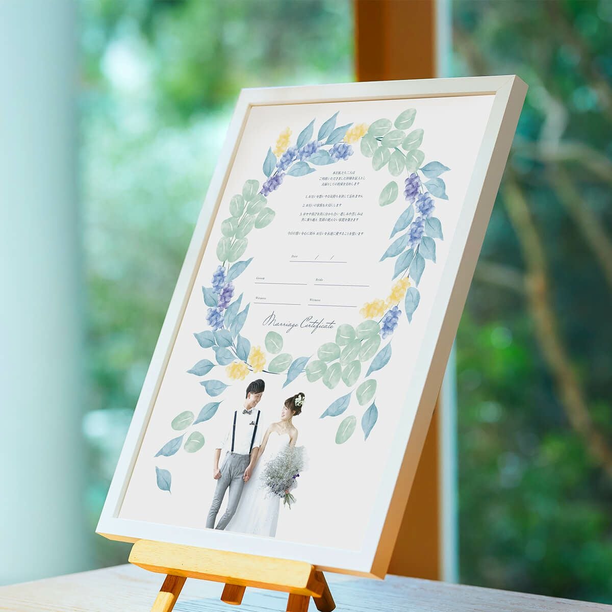 ナチュラルおしゃれなリースデザインの結婚証明書をかかげる新郎新婦
