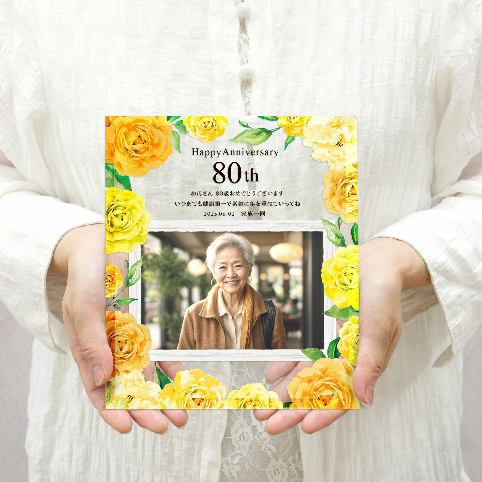 傘寿・米寿祝いのガラスフォトフレームを手に持っている