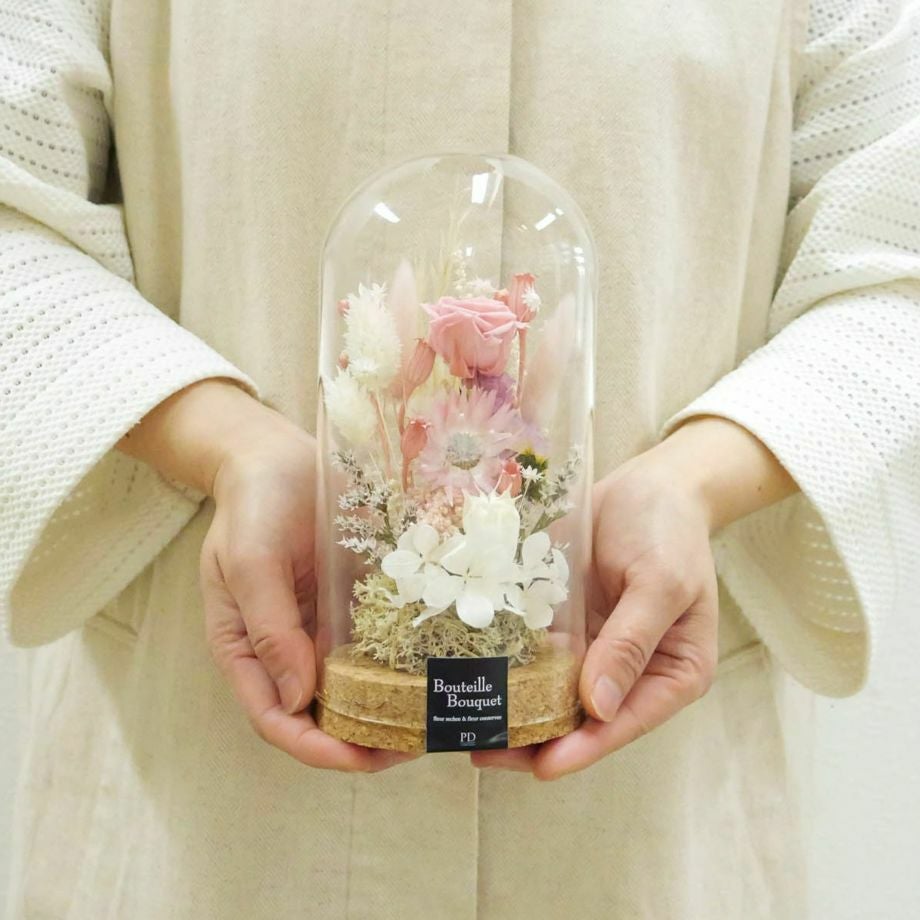 ガラスドームフラワーMサイズを手に持っている