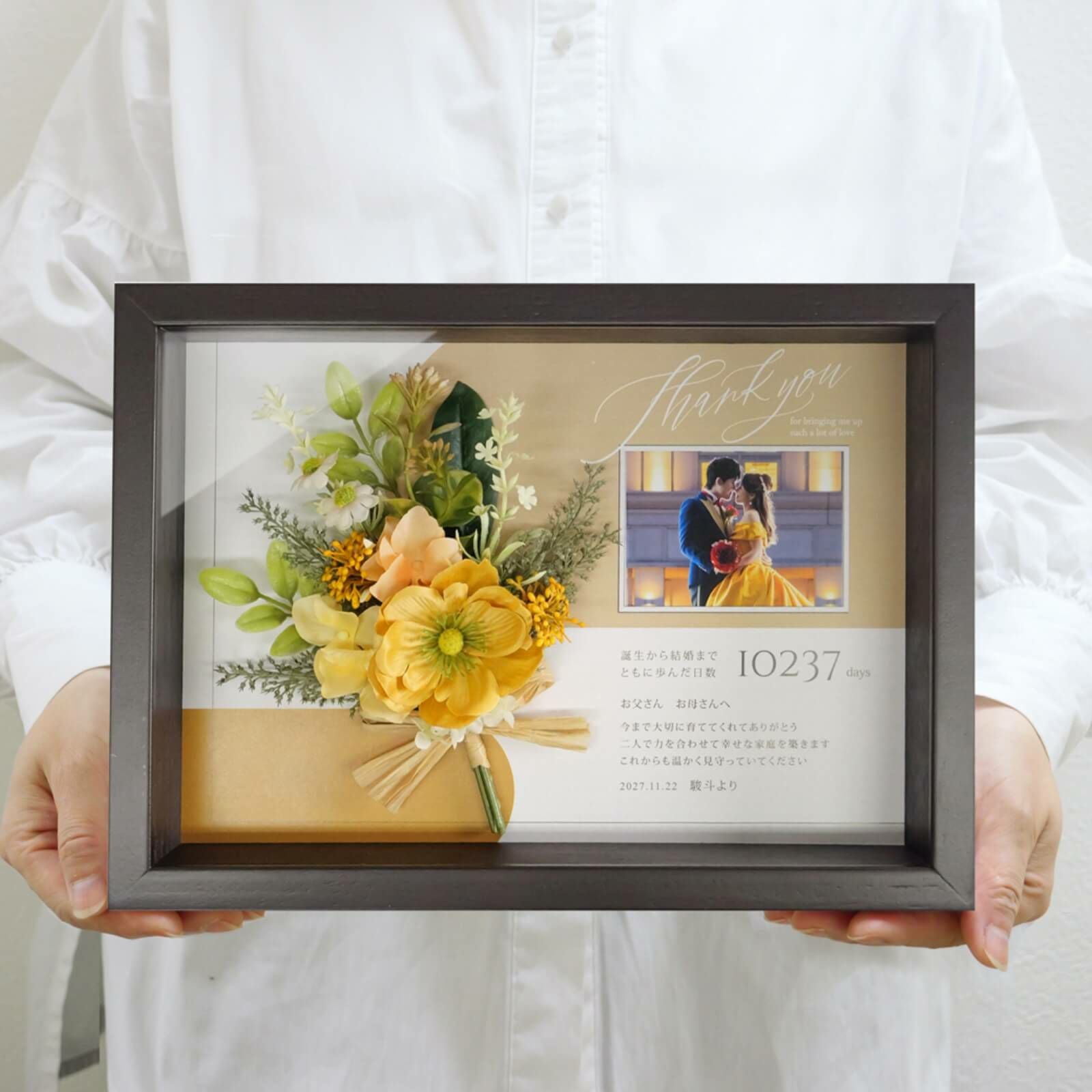 秋婚にもぴったりなカラーの子育て感謝状を手に持っている