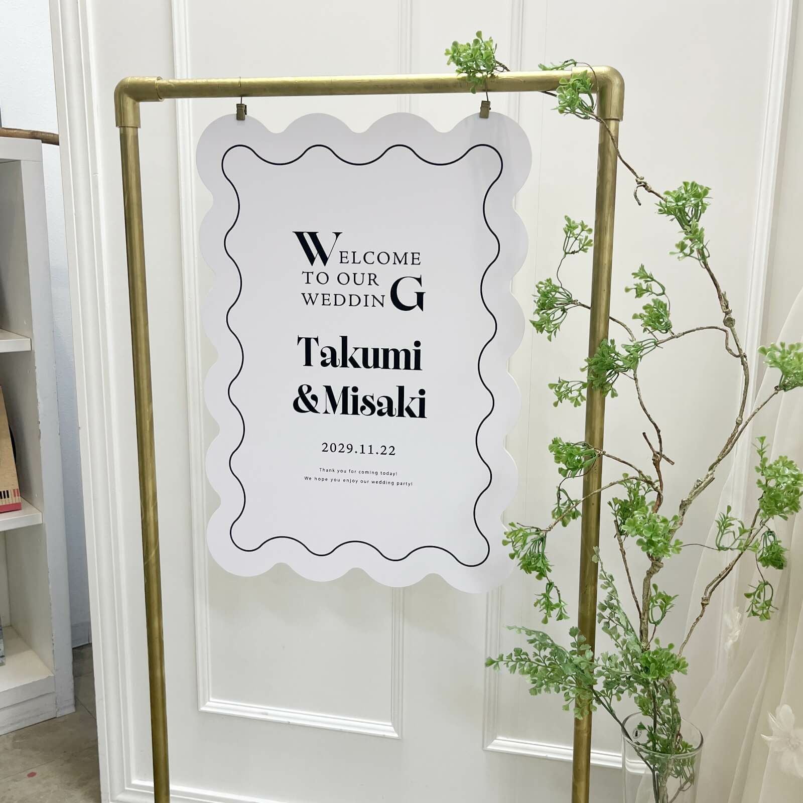ゴールドのイーゼルに吊るしたうねうね型ウェルカムボード